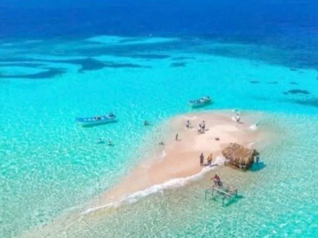 Luftaufnahme einer kleinen Sandbankinsel, umgeben von klarem türkisfarbenem Wasser